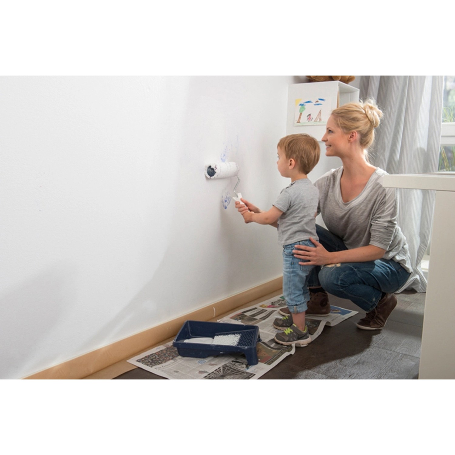 Mutter und Kind streichen Wand mit Histor Clean Wandfarbe Weiß seidenmatt.