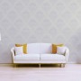 Weiße Tadessi Vliestapete mit elegantem Barock-Ornamentmuster in einem Wohnzimmer mit Sofa und Stehlampe.