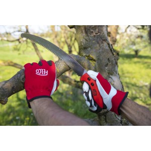 Felco Baumsäge 630 in Aktion: Gebogene Säge schneidet Ast, gehalten von Händen mit roten Felco-Handschuhen.