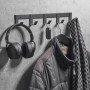 Schwarze SOTECH Blackline ALBA Hakenleiste mit 4 Haken an grauer Wand, behängt mit Kopfhörern, Schlüssel, Jacke. Garderobenleiste.