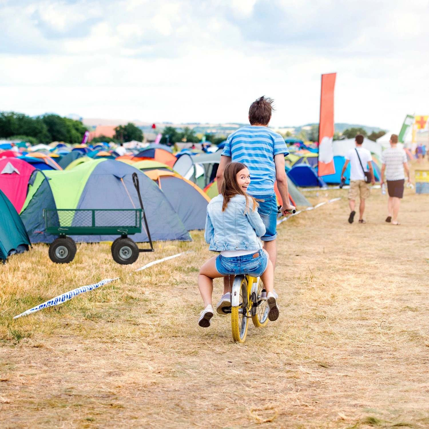 Dunkelgrüner Stahl Handwagen mit Luftreifen auf einem Festivalgelände. Ideal für Camping & Zubehör.