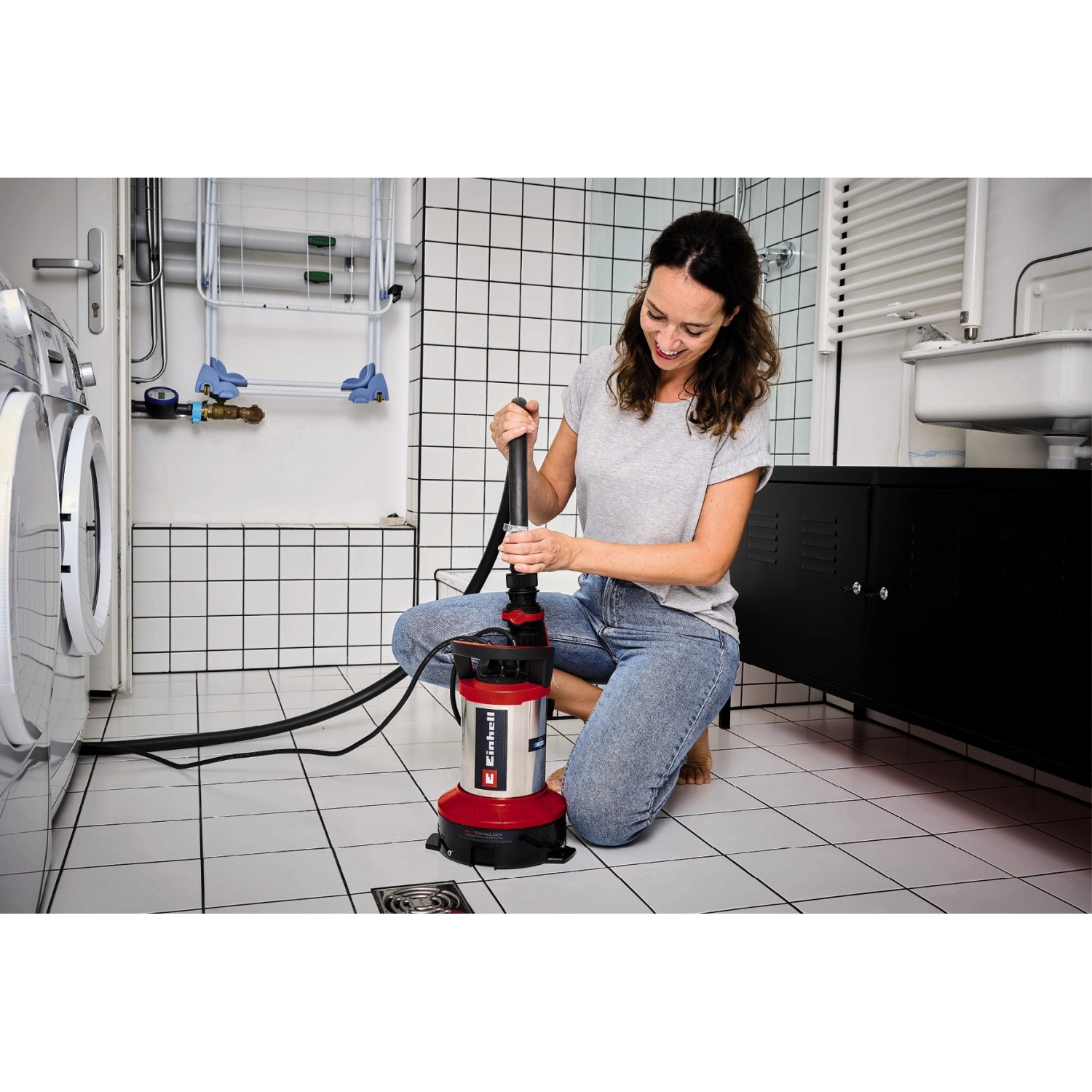 Frau bedient Einhell GE-DP 7535 N LL ECO Schmutzwasserpumpe im Bad.