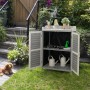 Grauer Costway Gartenschrank aus Holz mit geöffneten Türen und Gartenwerkzeug im Hintergrund.