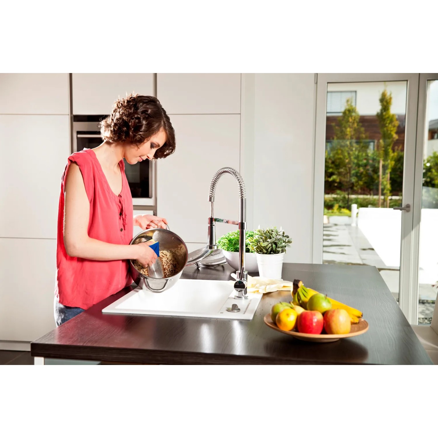 Frau spült Topf mit Vileda Glitzi Plus Topfreiniger in der Küche.