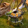 Petromax Atago Grill-Set SK40: Kompakter Gasgrill mit Grillspießen und Speisen auf dem Grill.