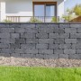Mauer aus grauen EHL Verona Antik Light Mauersteinen im Garten.