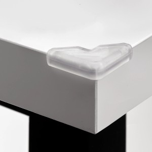 Transparenter Hettich Eckenpuffer aus Kunststoff (30x30x8,5mm) auf einer Tischkante.