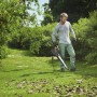 Mann nutzt Stiga Elektro-Laubbläser BL 130c V im Garten, um Laub zu entfernen.