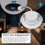 Weißer, dimmbarer LUXULA LED Einbauspot (Ø 75mm) mit Farbwahl und Netzteil vor Wohnzimmer Hintergrund.