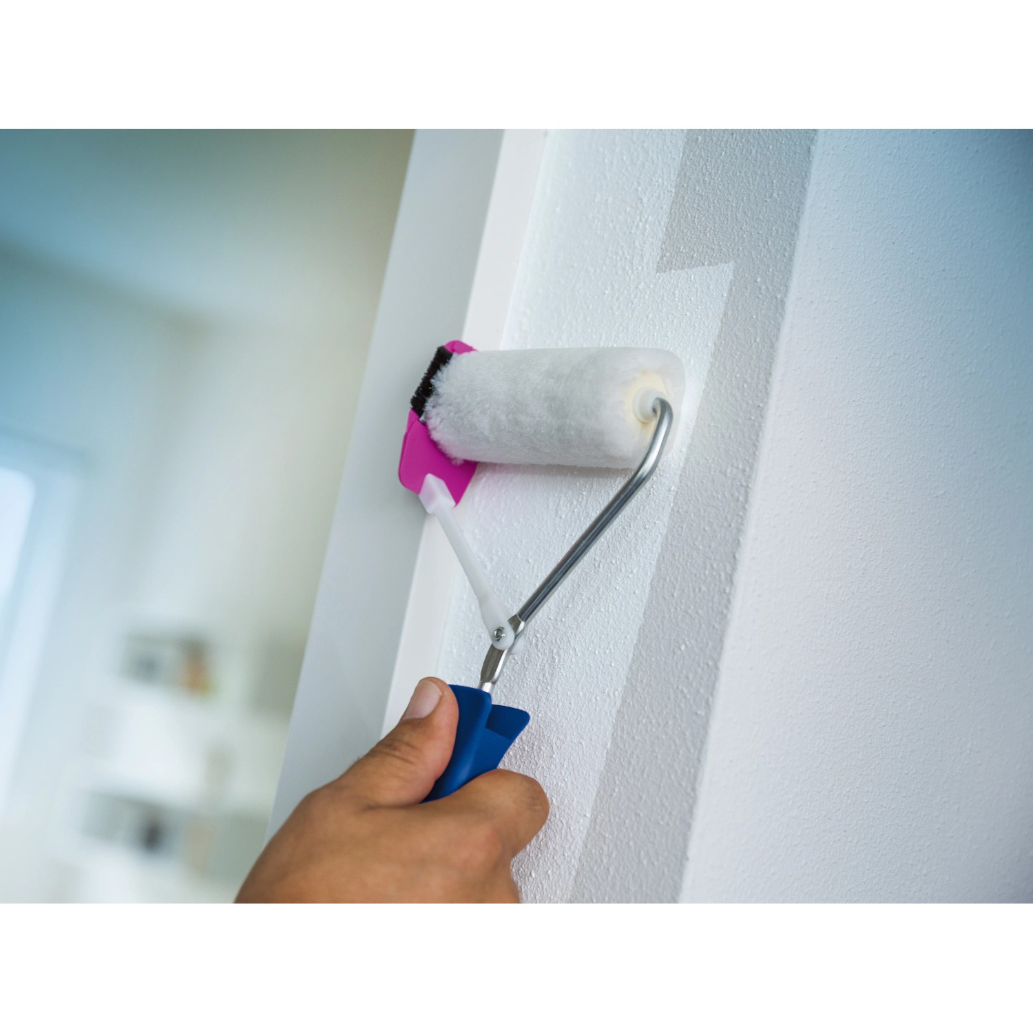LUX Wandkantenroller 10 cm im Einsatz: Hand führt Farbroller an einer weißen Wand entlang.
