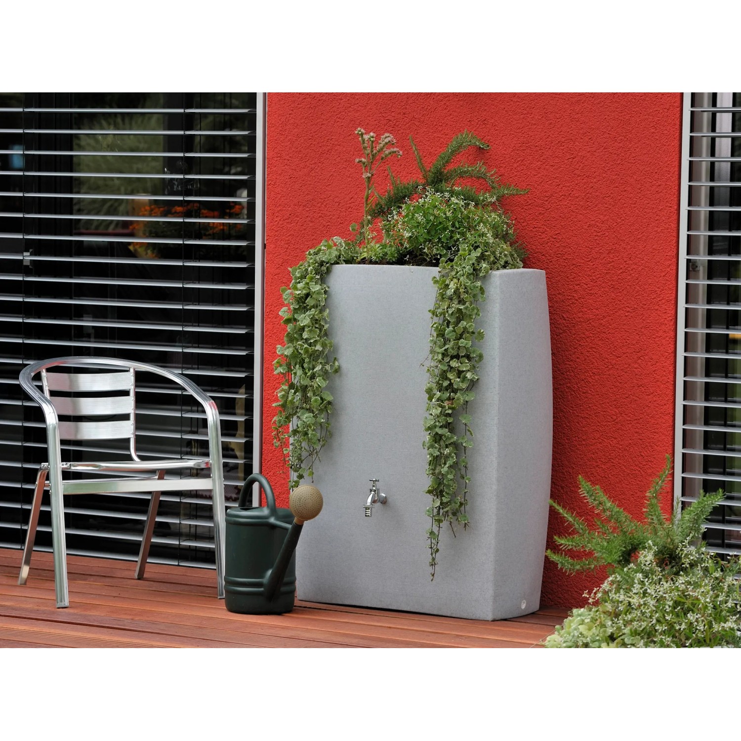 Arves Regentonne Noblesse 275 l Granit mit Bepflanzung und Gießkanne im Garten.