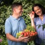 Glückliches Paar mit Gemüseernte aus Floragard Bio-Erde im Garten.