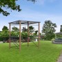 Leco Luxus-Grillpavillon 2,35x1,50m in Holzoptik im Garten, mit Ablageflächen und transparentem Dach.