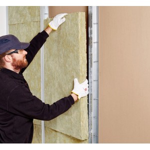 Rockwool Sonoroll Trennwanddämmung (40mm) wird von einer Person in eine Wand eingesetzt.