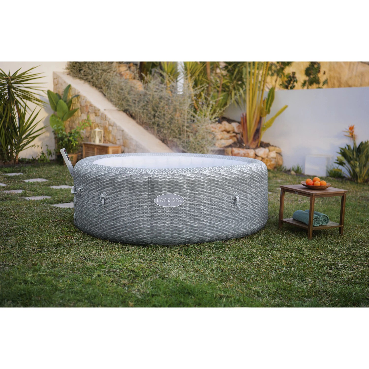 Grauer aufblasbarer Bestway Whirlpool Bali AirJet in Rattan-Optik im Garten, sprudelnd, für 6 Personen.
