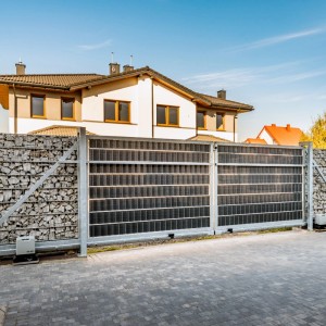 Graue Primaflor Polyrattan Sichtschutzstreifen am Zaun eines Hauses.