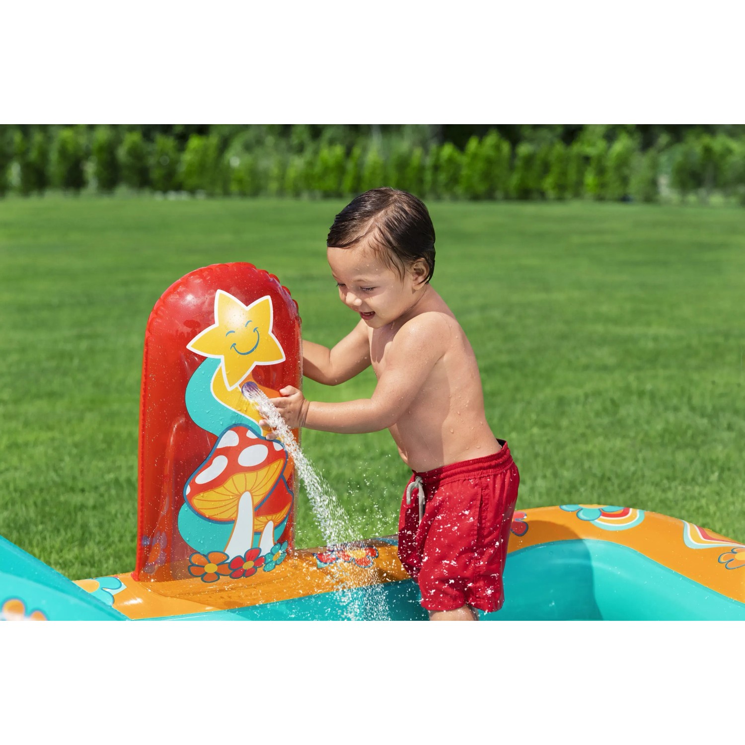 Kind spielt mit Bestway Wasserspielcenter Retro Welt mit Rutsche und Sprinkler im Garten.