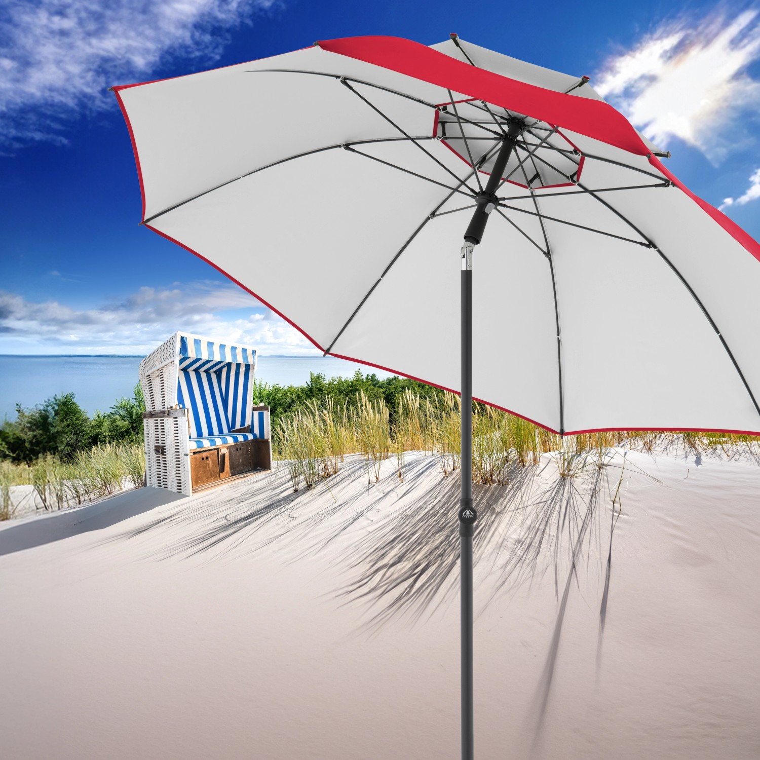 Roter Doppler Strandschirm Windprofi Neo 200 am Strand mit blau-weißem Strandkorb.