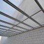 Anthrazit Terrassenüberdachung Solis Alu mit Hohlkammerplatten an Hauswand.