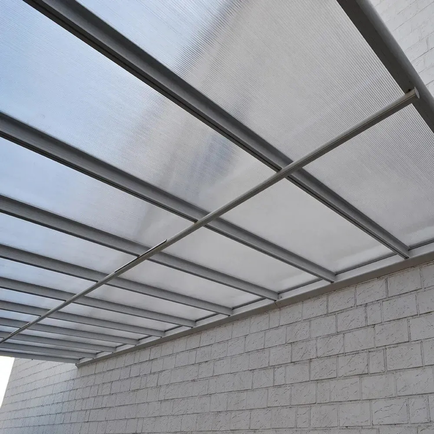 Anthrazit Terrassenüberdachung Solis Alu mit Hohlkammerplatten an Hauswand.