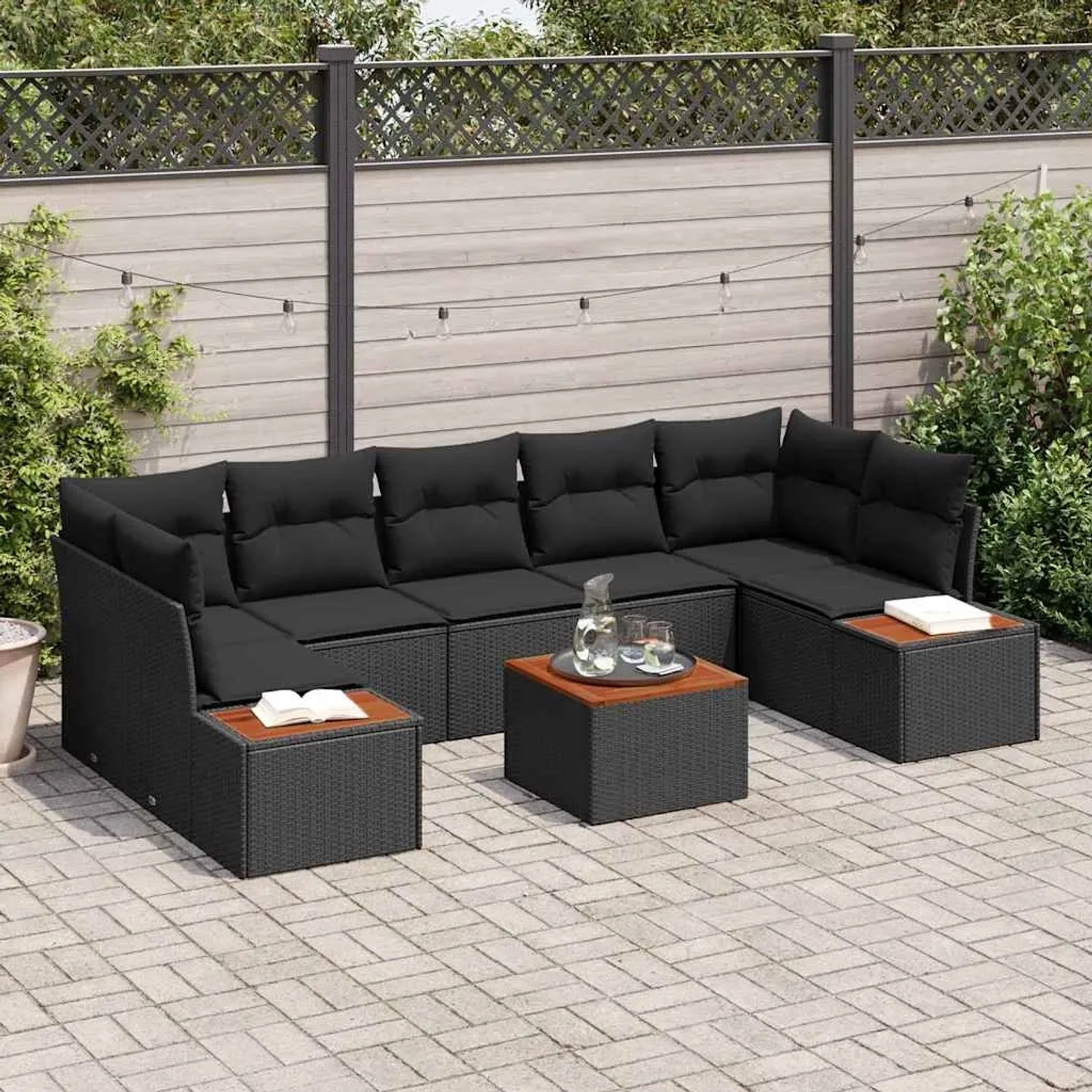 Schwarzes 8-teiliges Garten-Sofa-Set aus Poly Rattan mit Kissen und Tisch.