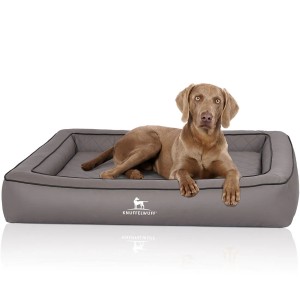 Hund liegt entspannt im grauen Knuffelwuff Hundebett Hampstead aus Kunstleder, orthopädisch.