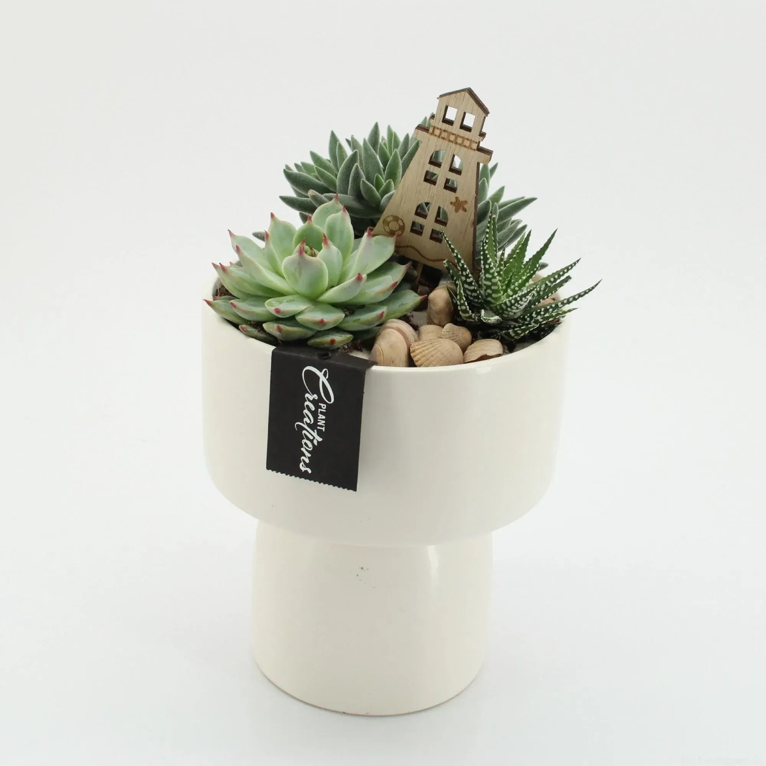 Sukkulenten-Arrangement im weißen Keramiktopf mit Deko-Leuchtturm, Topf ca. 16cm Ø.