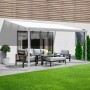 Weiße Home Deluxe Terrassenüberdachung Solis aus Alu mit Sitzgruppe auf Terrasse.