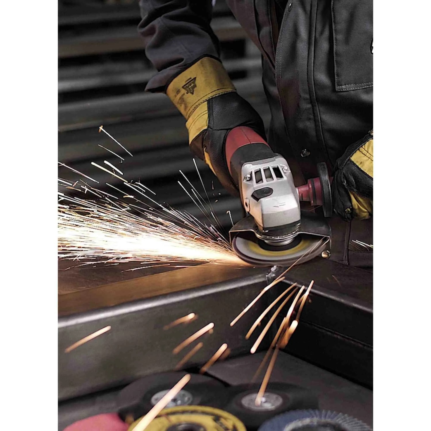 Handwerker schleift Stahl mit Klingspor SMT 624 Schleifmopteller 125mm am Winkelschleifer; Funken sprühen.
