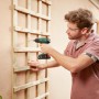 Mann schraubt mit Bosch Akku-Bohrschrauber EasyDrill 18V-40 eine Holzkonstruktion an die Wand.