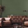 Wohnzimmer mit dunkelgrüner Bricoflor Vliestapete in Oliv Uni und braunen Ledersesseln.