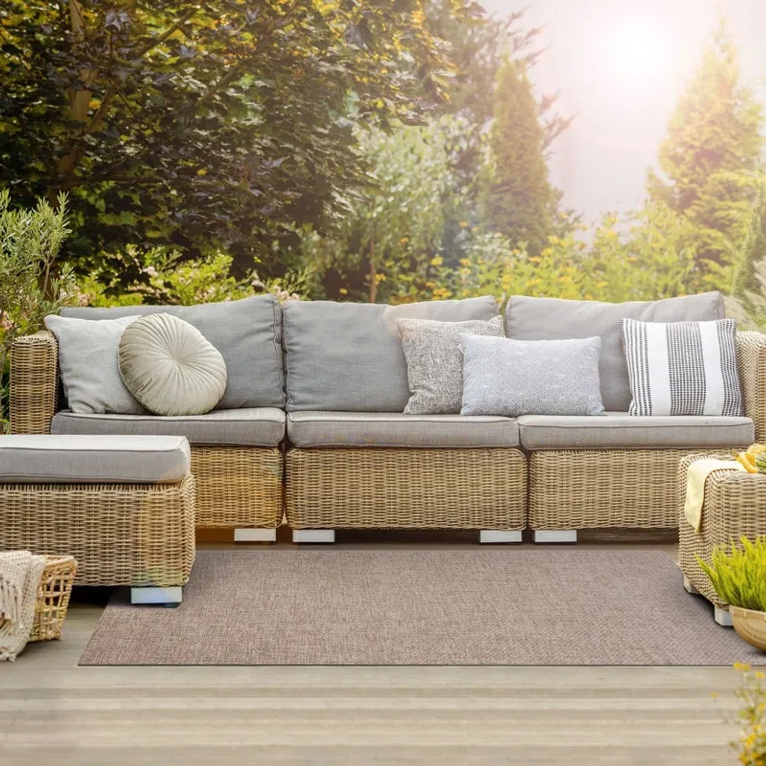 Wetterfester KARAT Outdoor Teppich Trani in Braun auf Terrasse mit Gartenmöbeln.