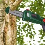 Bosch Akku Teleskop-Kettensäge UniversalChainPole 18 schneidet einen Ast. Grüner Hochentaster mit Sägekette in Aktion, Sägespäne fliegen.