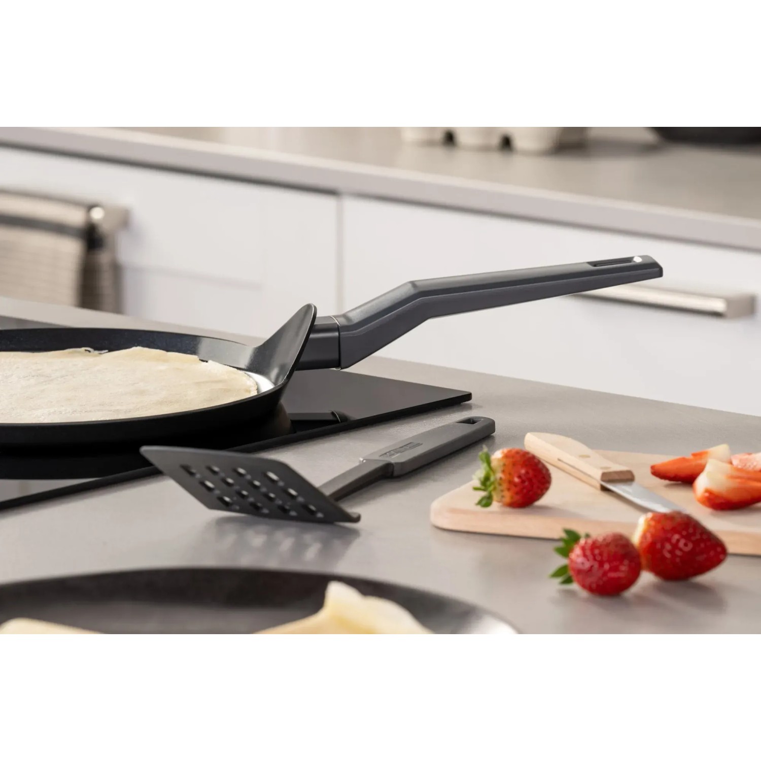 Fackelmann Crepepfanne Statement 25 cm mit Zubehör und Erdbeeren auf einem Tisch.