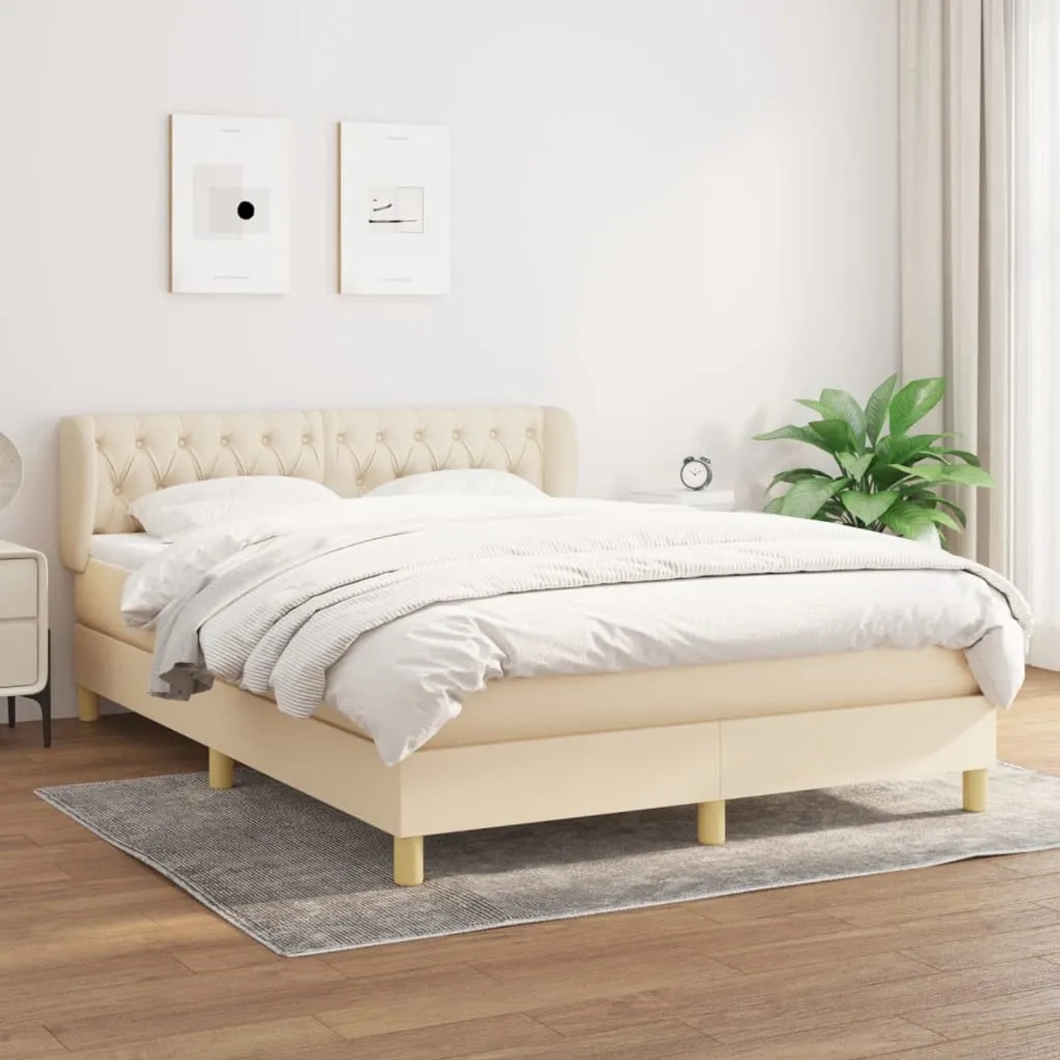 Cremefarbenes Boxspringbett 140x200 cm mit Stoffbezug und gestepptem Kopfteil.
