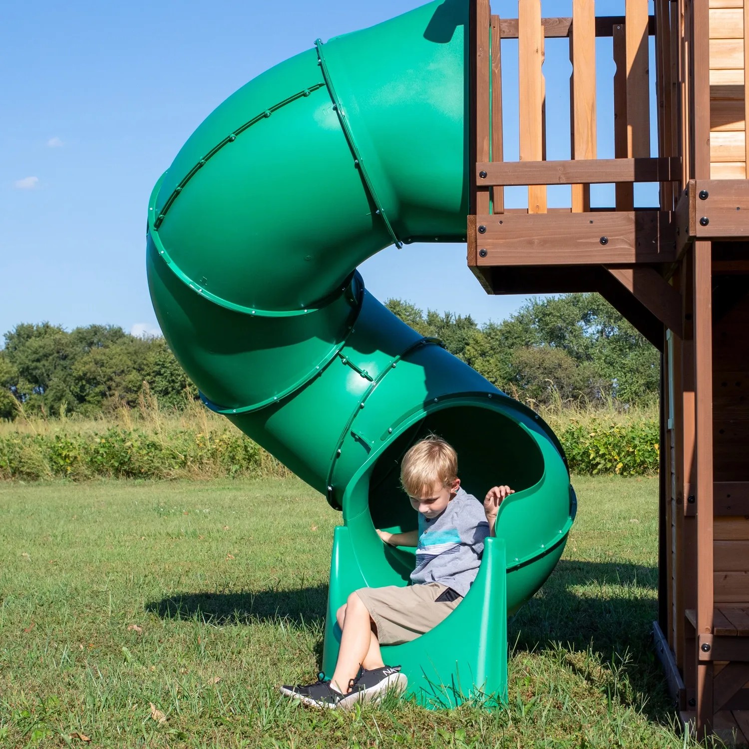 Kind rutscht grüne Röhrenrutsche am Backyard Discovery Spielturm Cedar Cove runter.