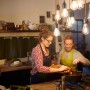 Zwei Frauen kochen unter Philips E27 LED Lampen in Glühlampenform in einer Küche.