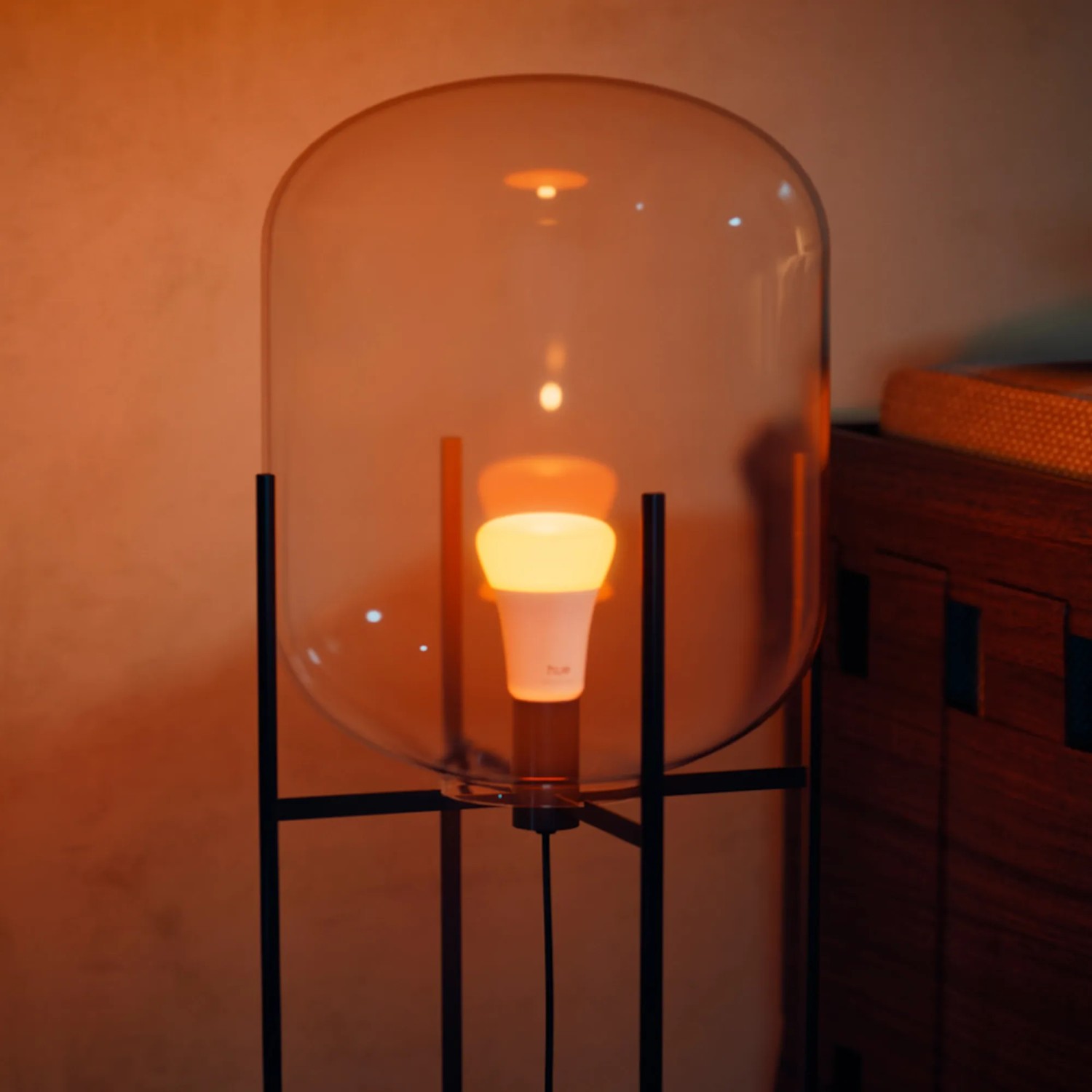 Philips Hue E27 LED-Lampe, 8,1W, warmweiß bis farbig, in Lampe mit Glasschirm.
