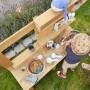 Home Deluxe Spielküche Mandu aus Holz mit Kind beim Spielen im Garten.