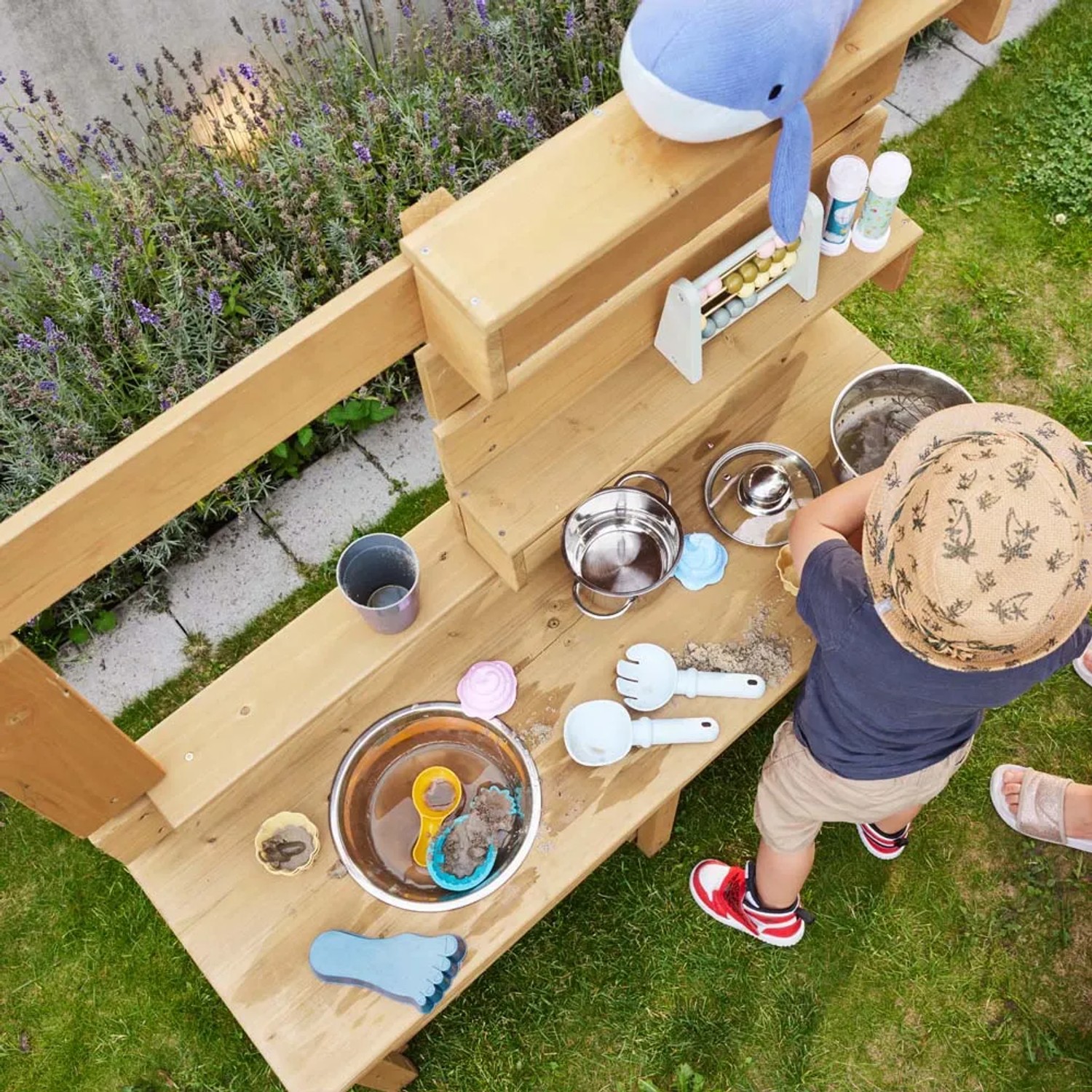 Home Deluxe Spielküche Mandu aus Holz mit Kind beim Spielen im Garten.