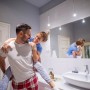 Lachendes Paar im Bad. Auf dem Waschtisch steht ein Relaxdays Muschel Set mit bunten Natur Muscheln als Deko.