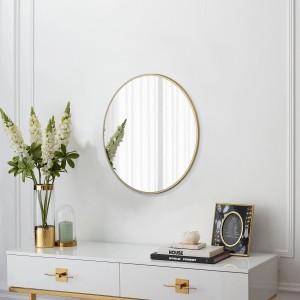 Runder DSK Designspiegel Picasso, Ø 50 cm, mit goldenem Rahmen an weißer Wand.
