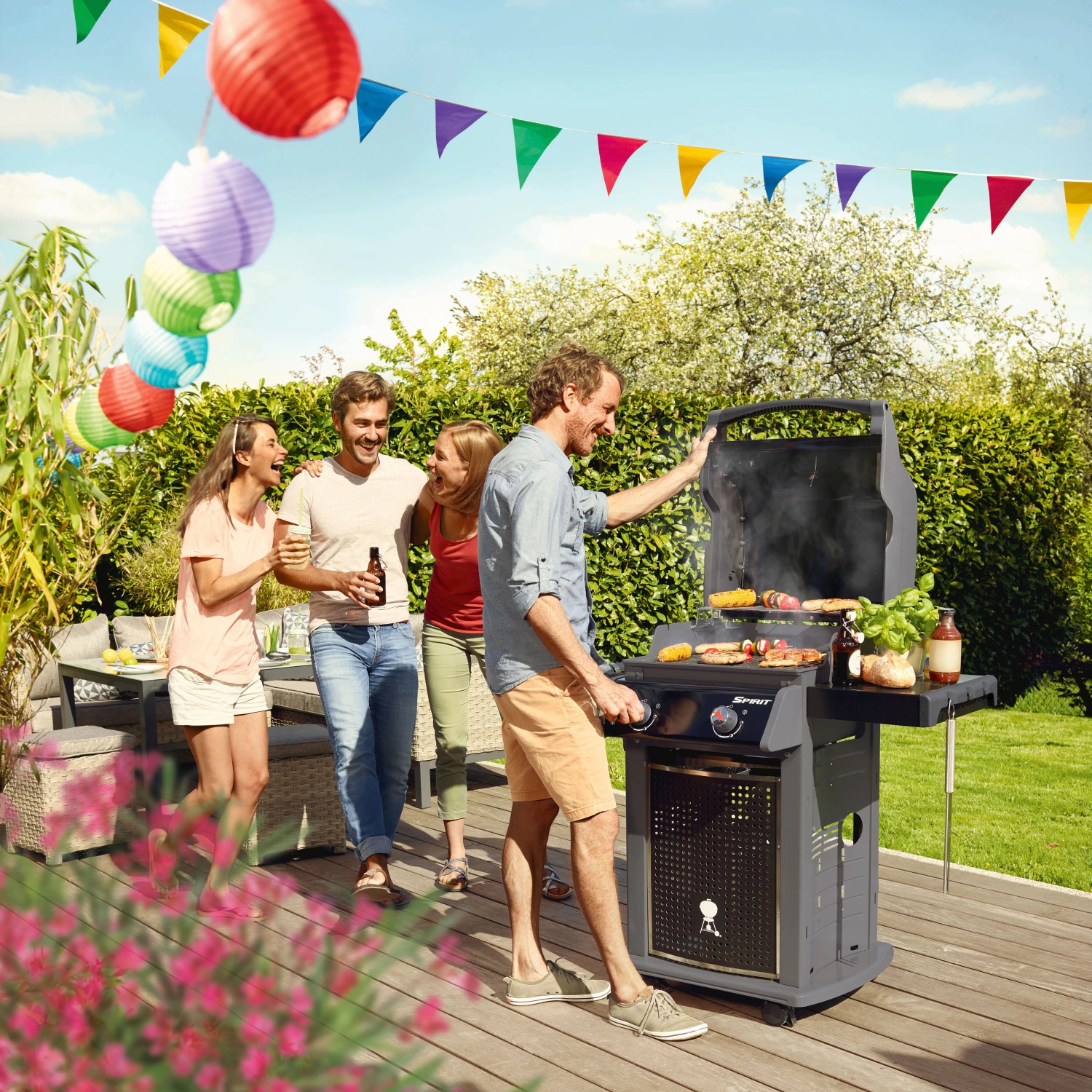 Weber Spirit E-220 Classic Gasgrill beim Grillen mit Freunden. Grill mit 2 Brennern und Seitenbrenner in Schwarz.