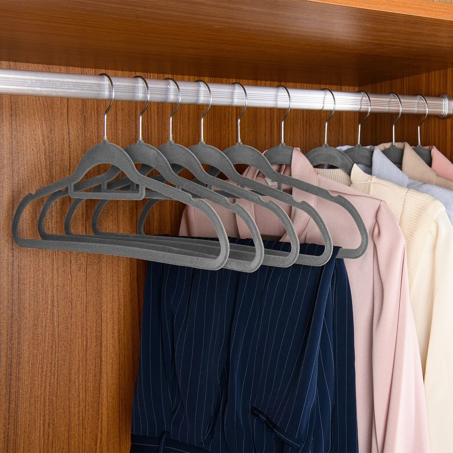 Graue Juskys Samt Kleiderbügel, 50er Set, hängen im Kleiderschrank mit Kleidung.