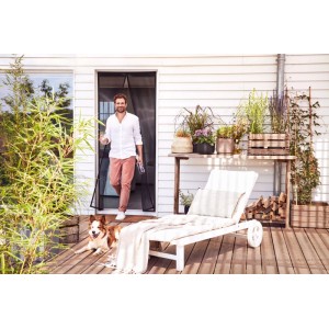 tesa® Insect Stop Magnetvorhang Tür, anthrazit, mit Mann und Hund auf Terrasse.