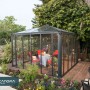 Canopia Ledro Pavillon 3.6x3.6 m, anthrazitgrau, mit Doppeltüren und Tischgruppe im Inneren.