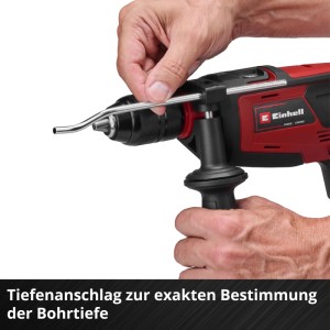 Einhell Akku-Schlagbohrmaschine: Hand justiert Metall-Tiefenanschlag am roten Gerät für präzise Bohrtiefe.