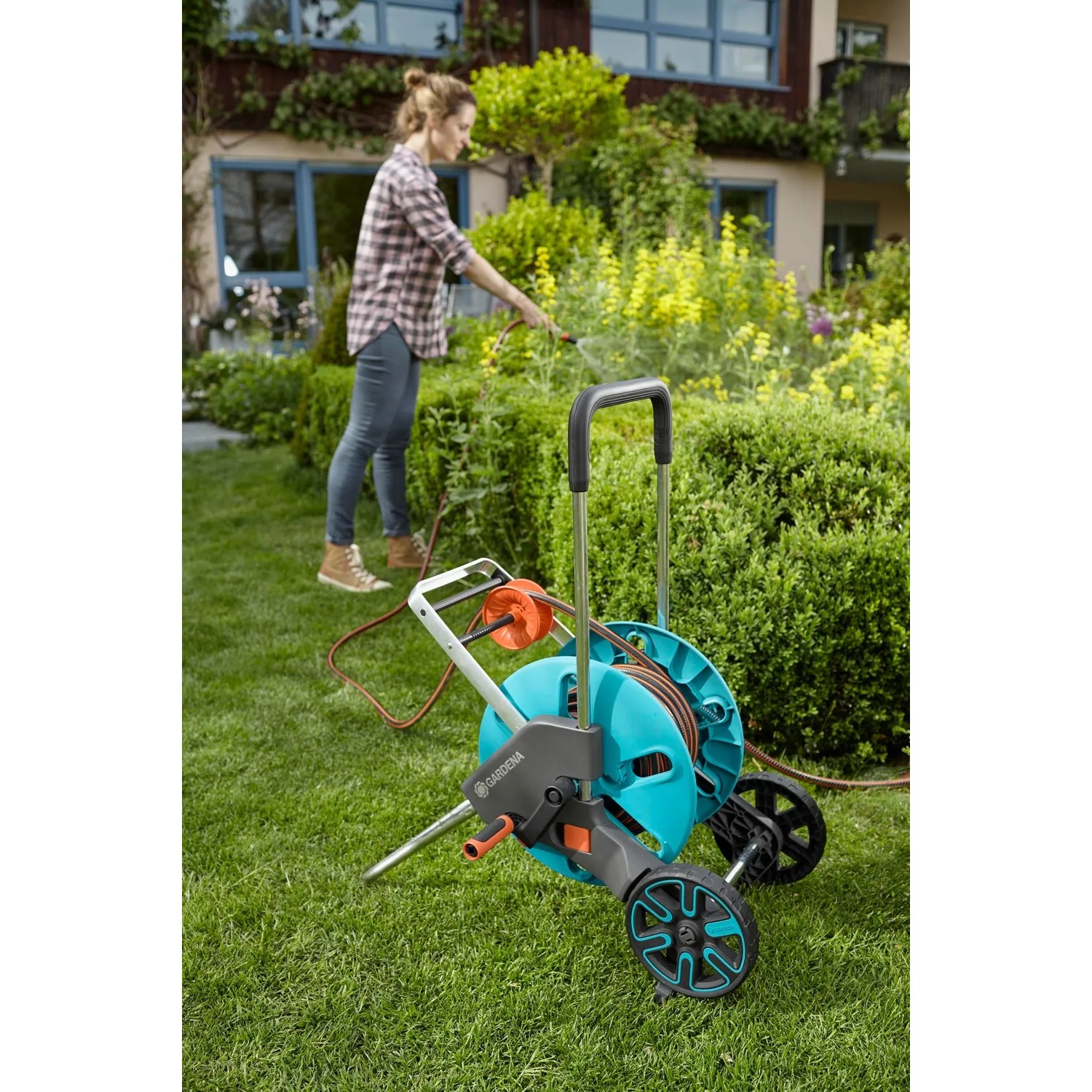 Gardena CleverRoll M Easy Schlauchwagen-Set mit 20m Schlauch und Spritze im Garten.