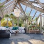 Palmako Gewächshaus Emilia 19 Grau, 19,1 m² mit Holzrahmen und Glas, eingerichtet als Wohnraum.