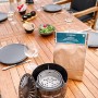 Feuerhand Tischgrill mit Kohle und Zubehör auf einem Holztisch.